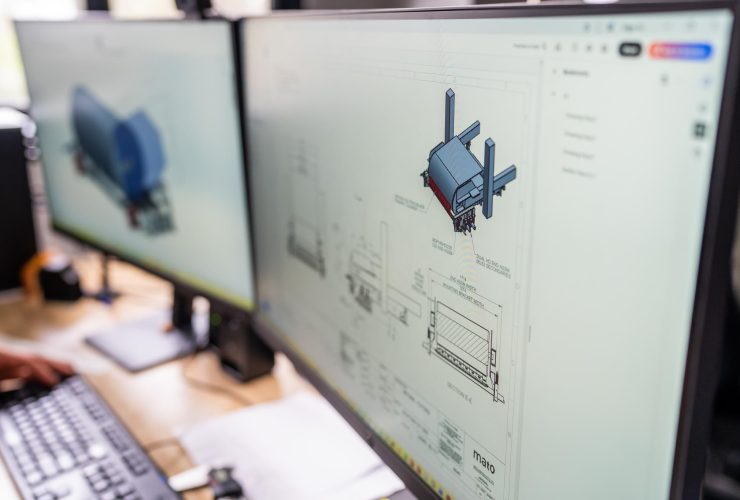 CAD software showing 3D engineering models on a workstation screen.